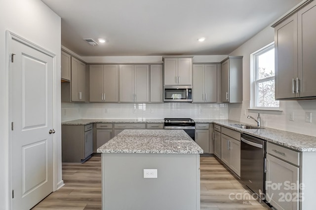 kitchen with gray cabinetry, a center island, and appliances with stainless steel finishes