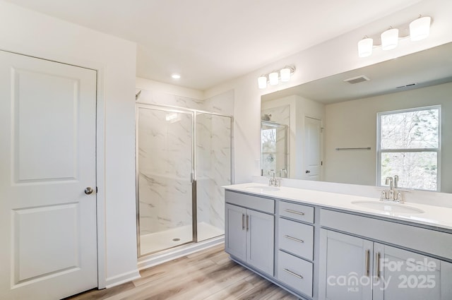 bathroom featuring vanity, an enclosed shower, and hardwood / wood-style floors