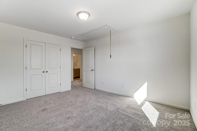 unfurnished bedroom with light colored carpet and a closet