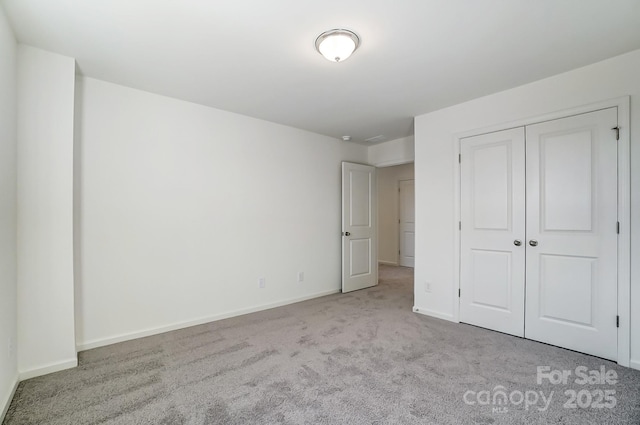 unfurnished bedroom featuring light carpet and a closet