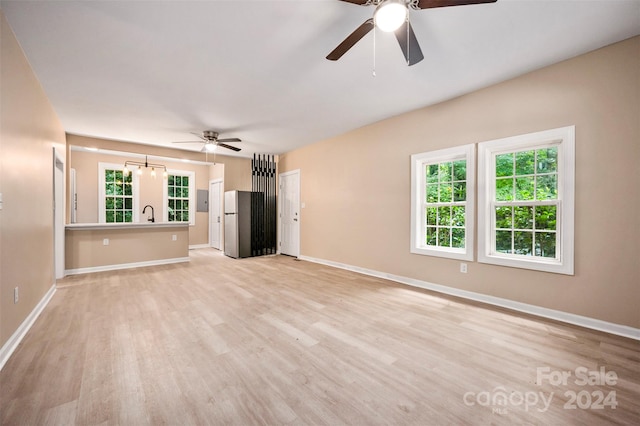 unfurnished living room featuring ceiling fan and light hardwood / wood-style floors