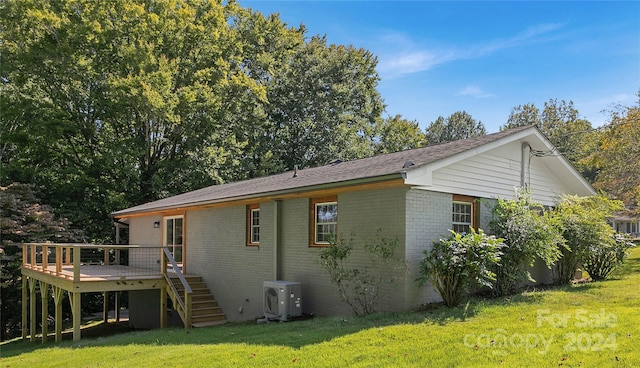 back of house with ac unit, a yard, and a wooden deck