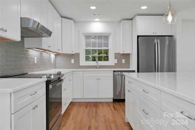 kitchen with range hood, hanging light fixtures, appliances with stainless steel finishes, light hardwood / wood-style floors, and white cabinetry