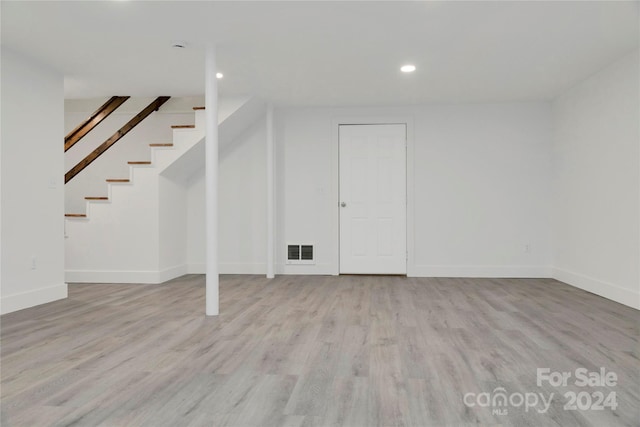 basement with light hardwood / wood-style flooring