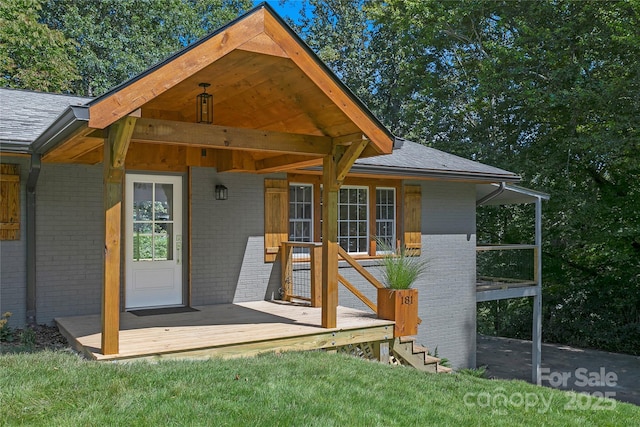 exterior space featuring brick siding and a shingled roof