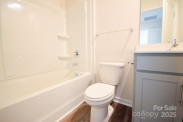 bathroom featuring toilet, baseboards, visible vents, wood finished floors, and vanity