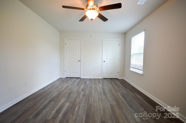 unfurnished bedroom with baseboards, ceiling fan, and dark wood finished floors