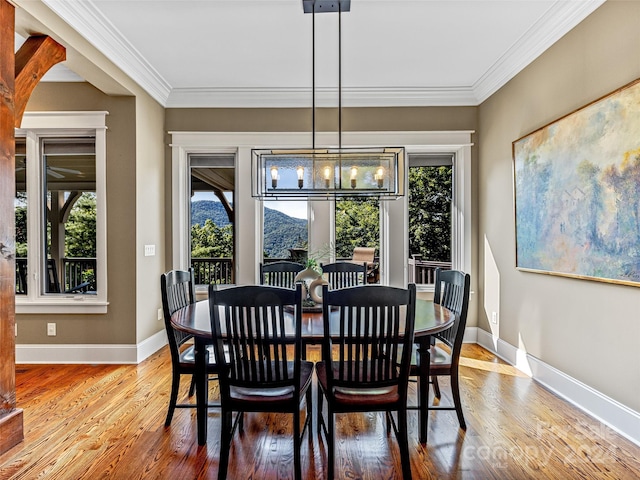 dining space featuring crown molding, an inviting chandelier, and hardwood / wood-style floors