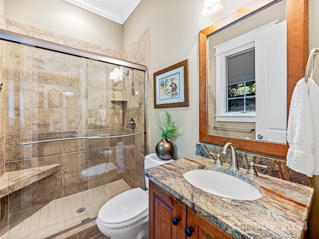 bathroom featuring a shower with door, vanity, toilet, and ornamental molding