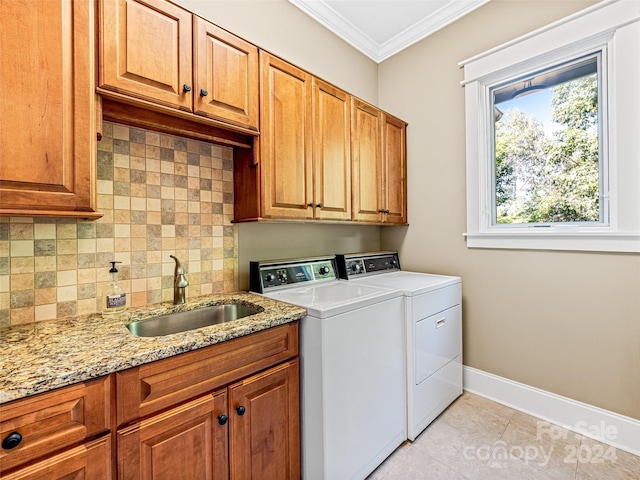 laundry area featuring cabinets, separate washer and dryer, crown molding, sink, and light tile patterned flooring