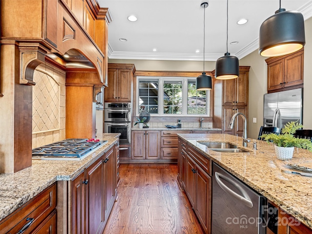 kitchen featuring pendant lighting, dark wood-style flooring, stainless steel appliances, a sink, and light stone countertops