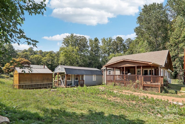 back of property featuring an outbuilding, a yard, and a wooden deck