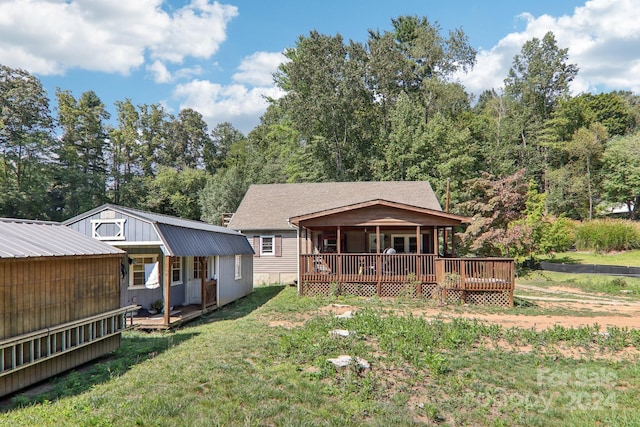 back of property with a porch and a yard