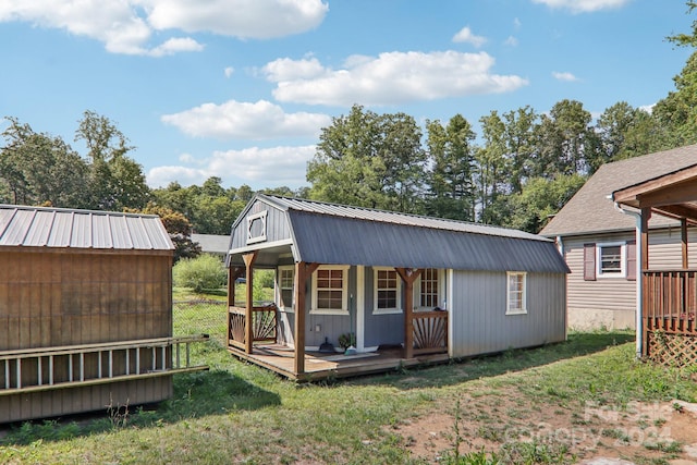 view of outdoor structure featuring a lawn and a porch