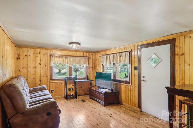 living room with wooden walls and light hardwood / wood-style floors