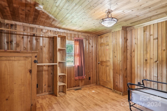 interior space with wooden ceiling, wood walls, and light hardwood / wood-style floors