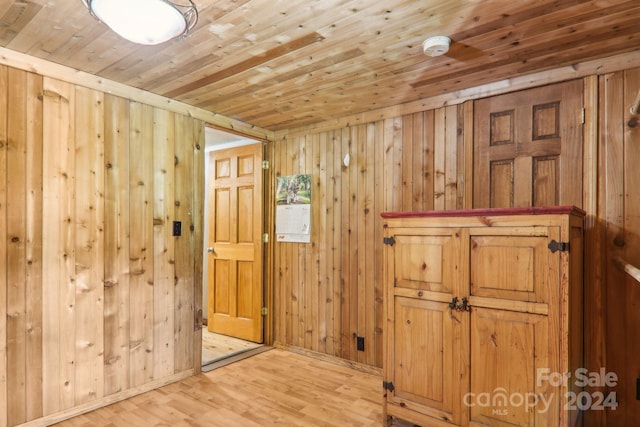 interior space featuring wood walls, wood-type flooring, and wooden ceiling