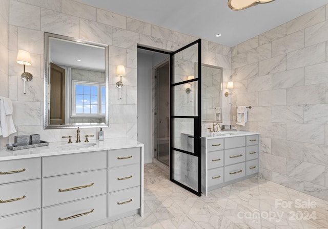 bathroom featuring tiled shower, vanity, and tile walls