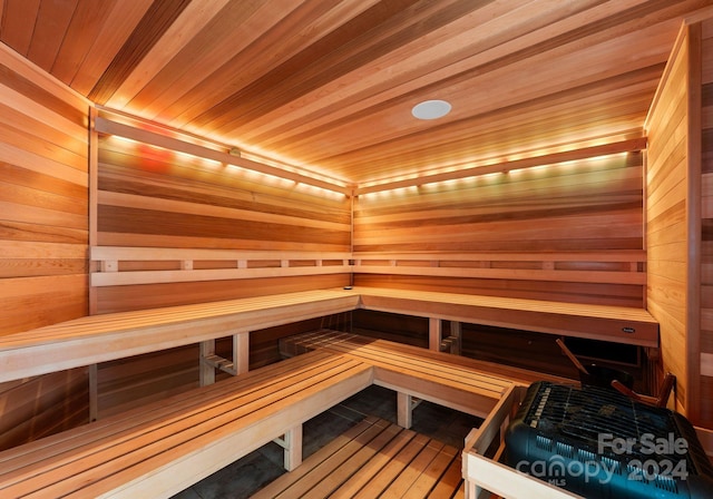 view of sauna featuring wooden ceiling and wood walls