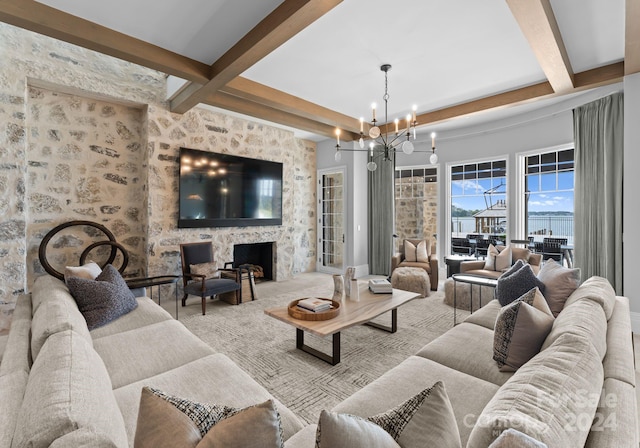 living room with a large fireplace, beam ceiling, and a notable chandelier