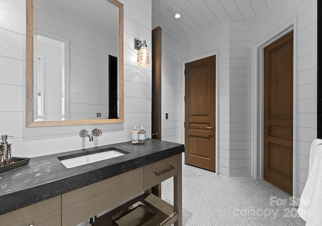 bathroom with vanity and wood walls