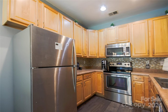 kitchen with appliances with stainless steel finishes, decorative backsplash, dark hardwood / wood-style flooring, and light brown cabinetry