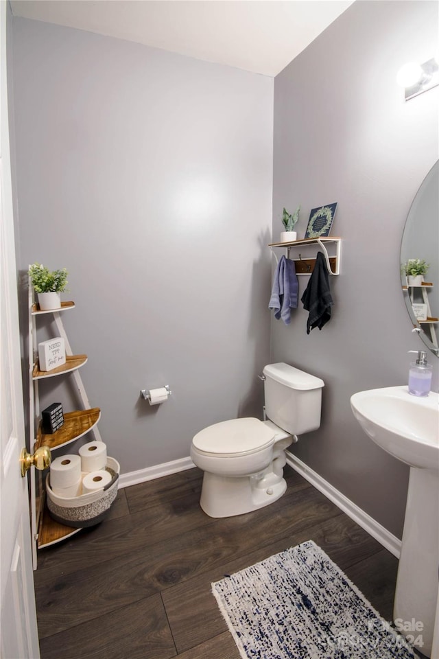 bathroom with toilet and hardwood / wood-style floors