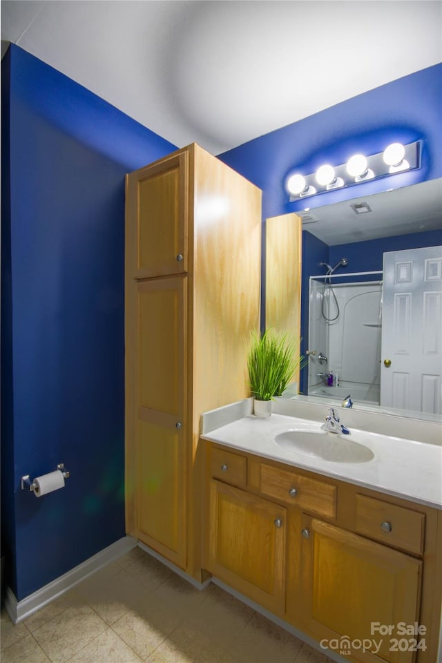 bathroom featuring vanity, tile patterned floors, and walk in shower