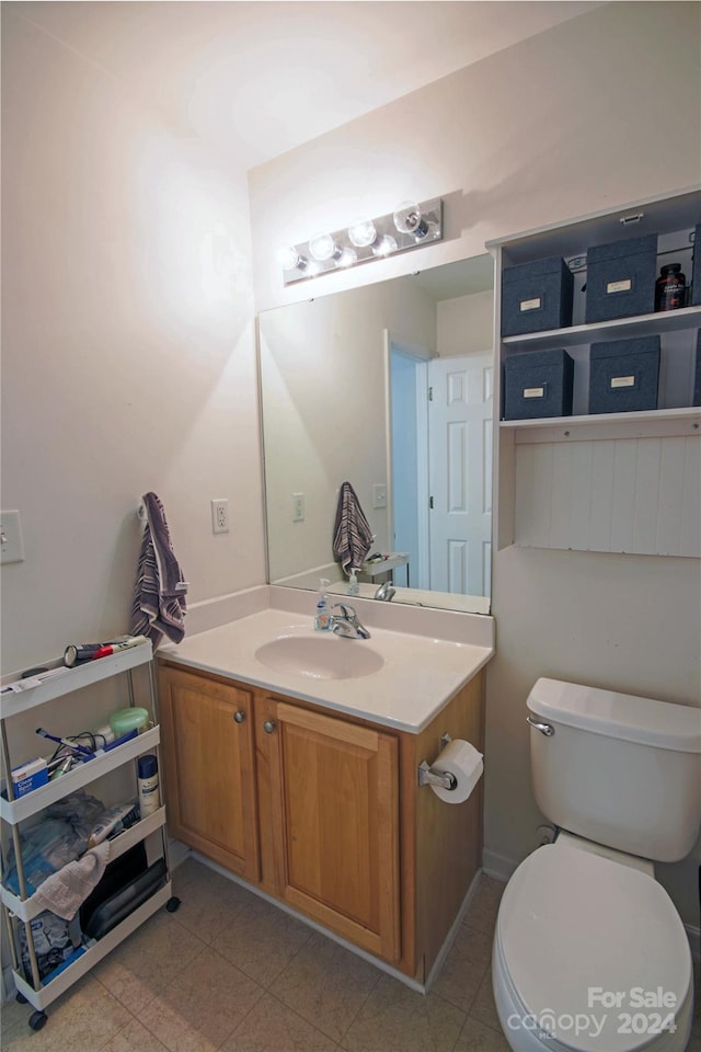 bathroom featuring tile patterned flooring, vanity, and toilet