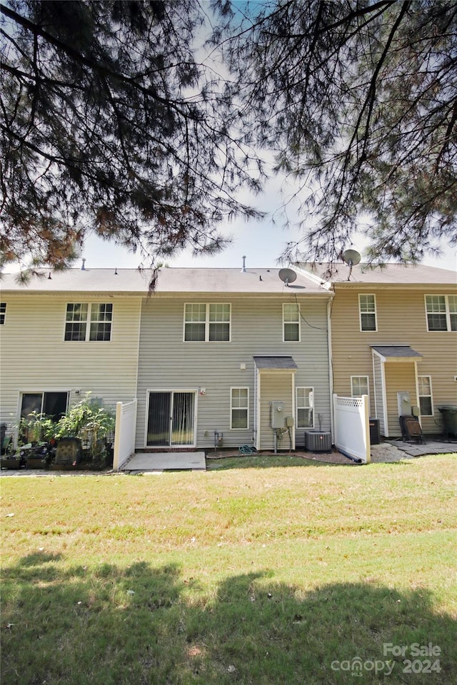 rear view of house with a yard and central air condition unit