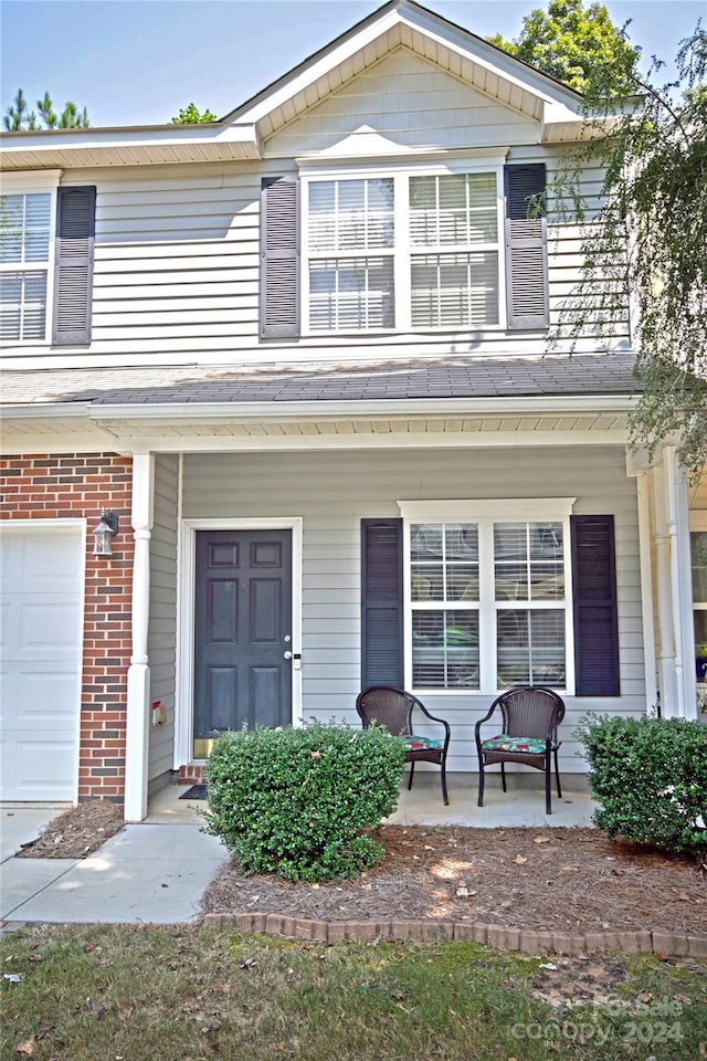 view of property featuring a garage and covered porch