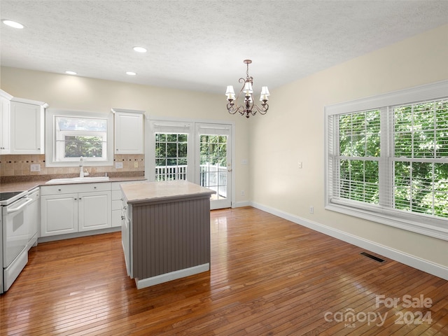 kitchen with a wealth of natural light, hardwood / wood-style flooring, and a center island