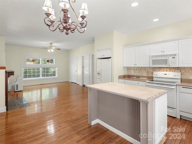 kitchen with hardwood / wood-style flooring, a center island, ceiling fan with notable chandelier, white appliances, and white cabinetry