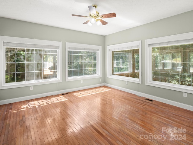 unfurnished sunroom featuring ceiling fan