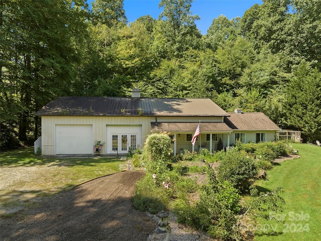 single story home featuring a garage, a front yard, and french doors