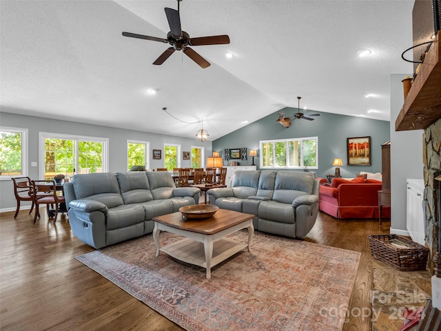 living room with lofted ceiling, dark hardwood / wood-style floors, ceiling fan, and a wealth of natural light