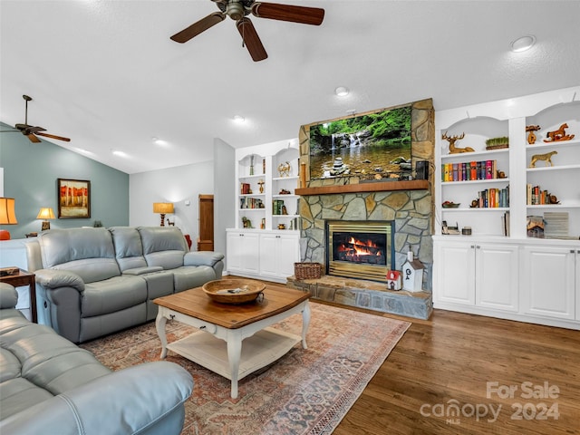 living room featuring ceiling fan, a stone fireplace, a textured ceiling, dark hardwood / wood-style floors, and vaulted ceiling