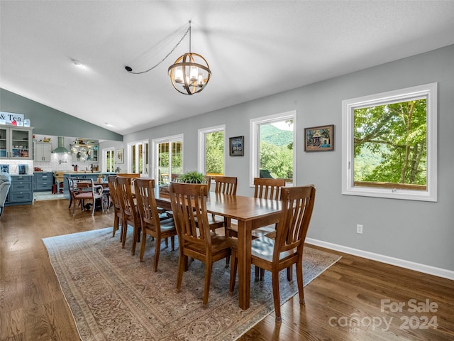 dining room with an inviting chandelier, lofted ceiling, and dark hardwood / wood-style floors