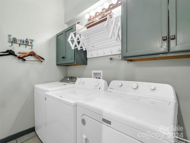 laundry room with cabinets, washer and dryer, and light tile patterned flooring