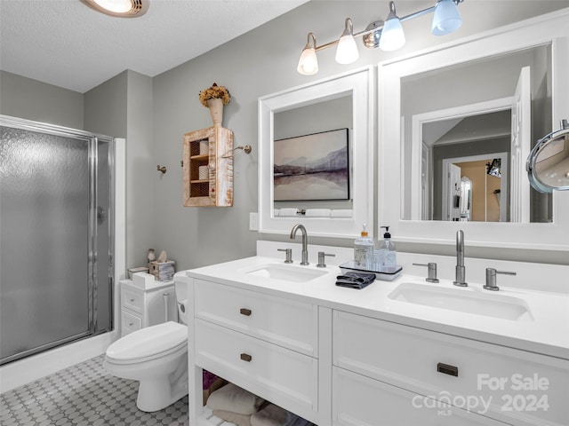 bathroom featuring walk in shower, a textured ceiling, vanity, and toilet