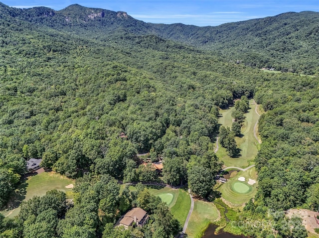 bird's eye view with view of golf course, a mountain view, and a wooded view