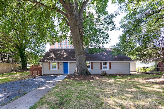 single story home featuring a front lawn and fence