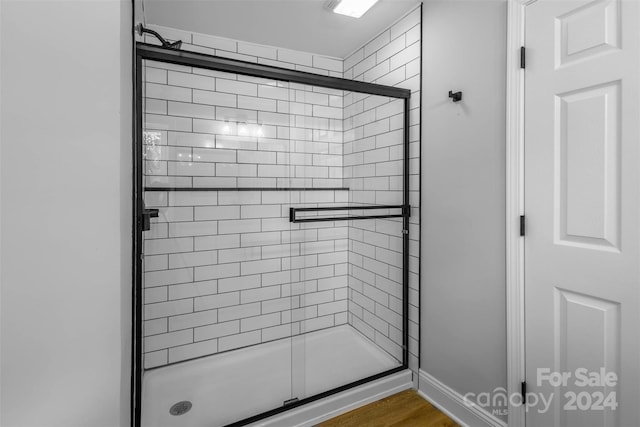 bathroom featuring hardwood / wood-style floors and walk in shower