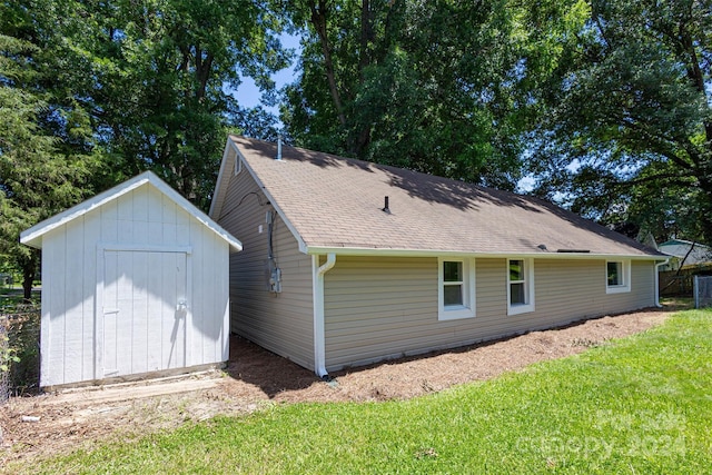 back of property with a lawn and a shed