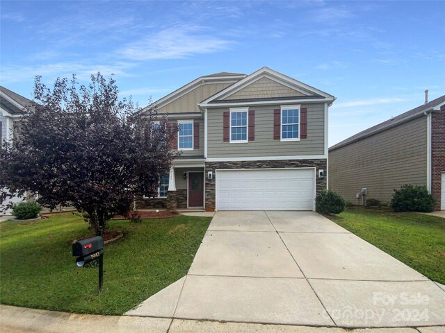 view of front of house featuring a garage and a front lawn