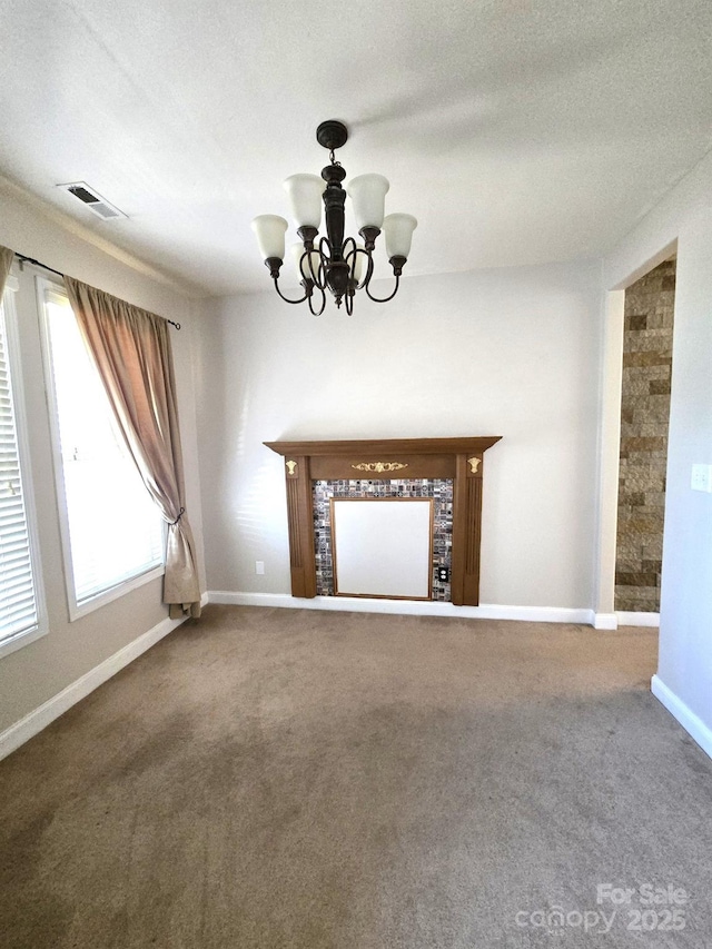 unfurnished living room with carpet, a textured ceiling, and a chandelier