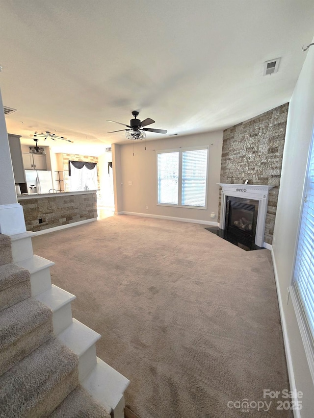 unfurnished living room featuring ceiling fan, carpet flooring, and rail lighting