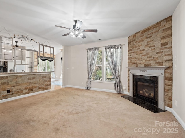 unfurnished living room featuring carpet floors, a high end fireplace, and ceiling fan