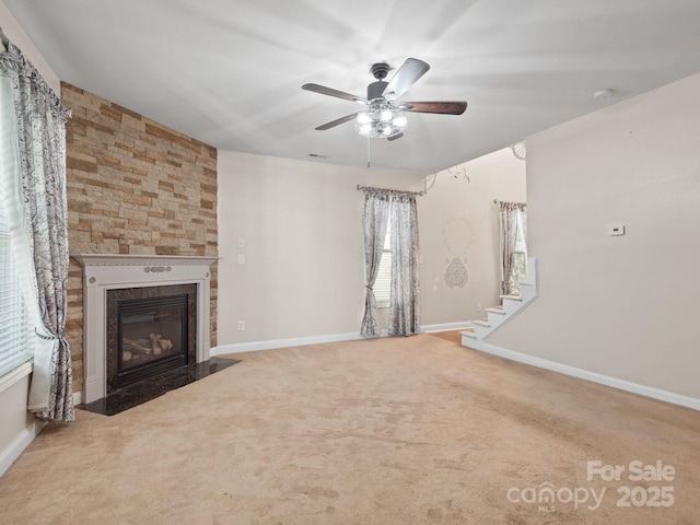 unfurnished living room with ceiling fan, a fireplace, and carpet