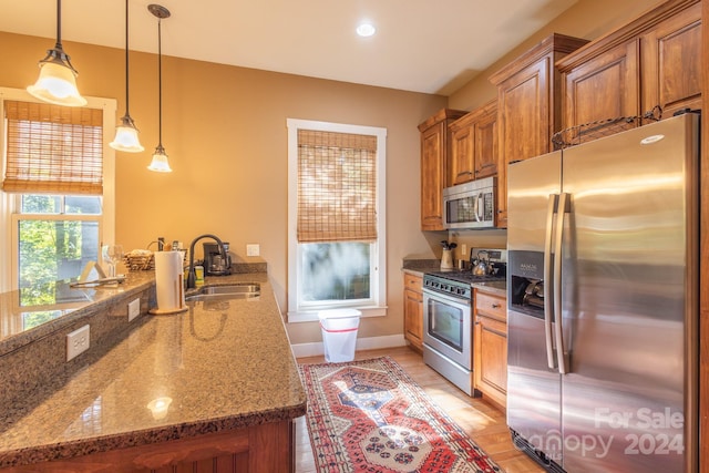 150-2 Saddle Notch Ln, Tuckasegee, NC 28783 - kitchen with appliances with stainless steel finishes, a sink, brown cabinetry, a peninsula, and stone counters